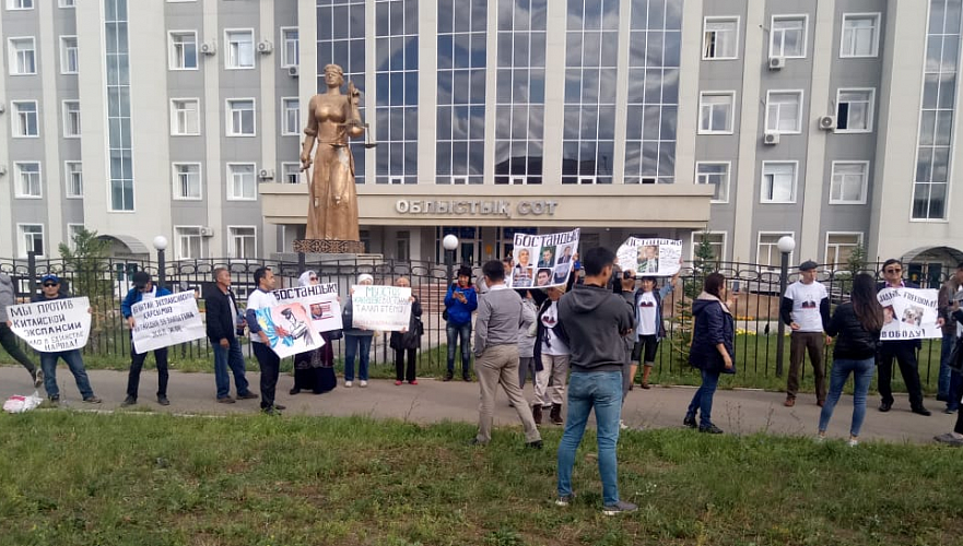 Десятки людей пришли с плакатами поддержать Джакишева к зданию суда в Усть-Каменогорске